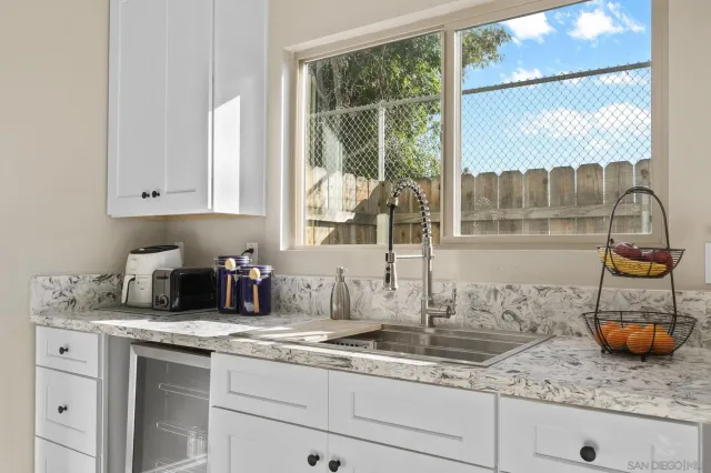 a kitchen with granite countertop a sink a counter and cabinets