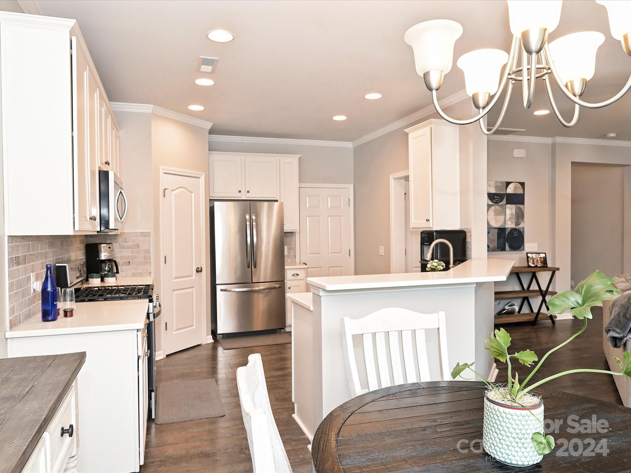 4041 Woodsmill Road Indian Land, SC 29707 - Photo 14 of 36 a kitchen with stainless steel appliances granite countertop a dining table chairs and a refrigerator