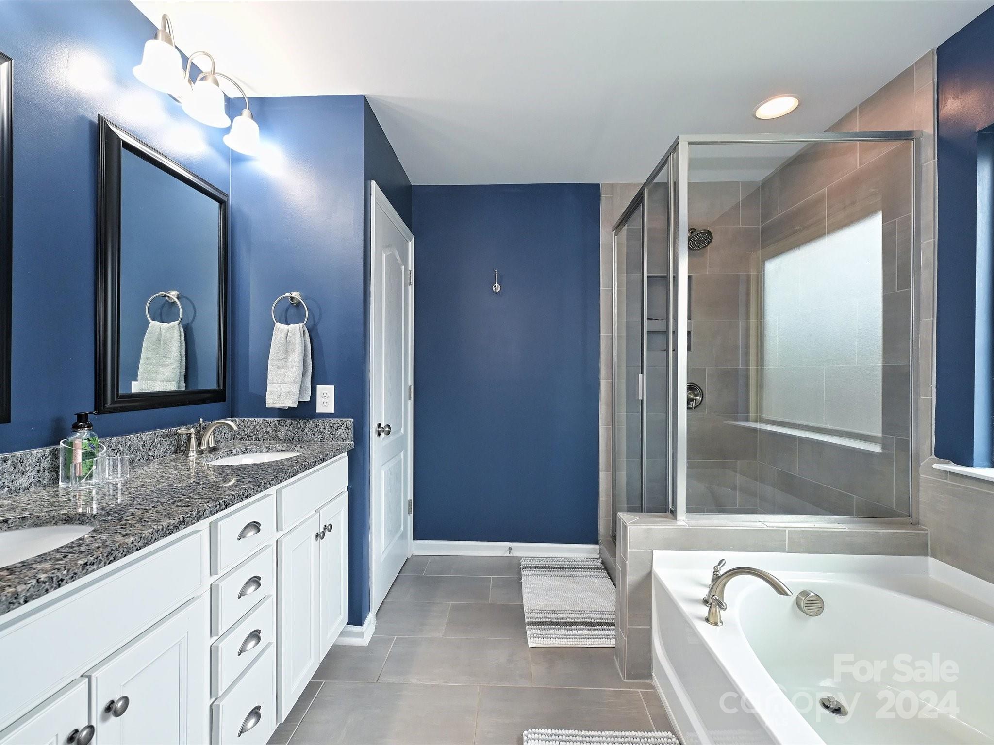 4041 Woodsmill Road Indian Land, SC 29707 - Photo 24 of 36 a spacious bathroom with a granite countertop tub sink shower and mirror