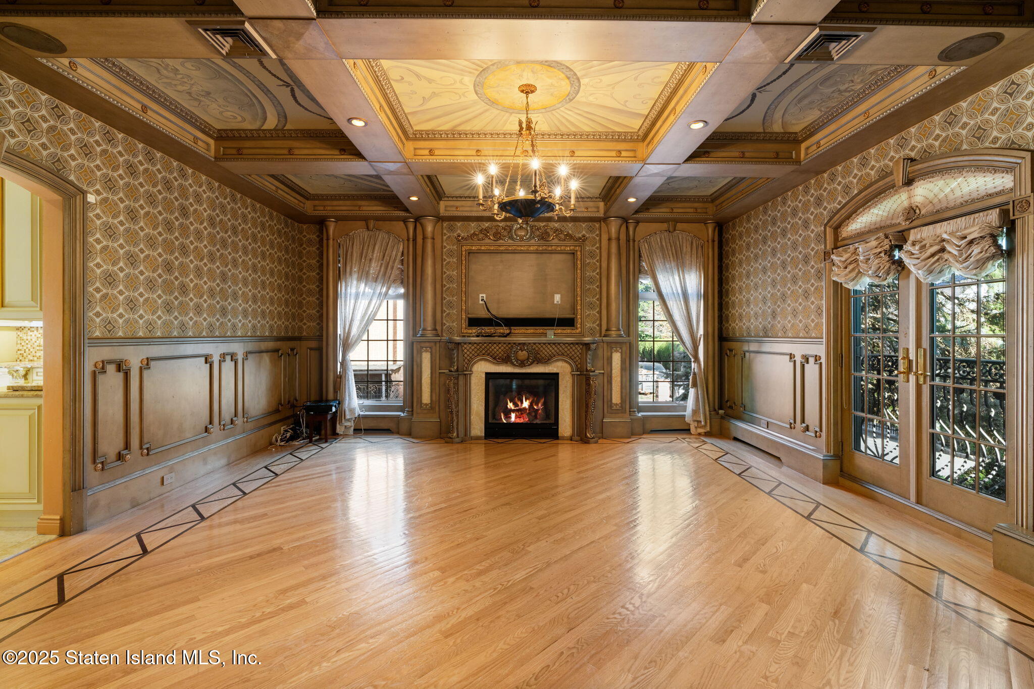 51 Romer Road Staten Island, NY 10304 - Photo 15 of 94 a view of a livingroom with a fireplace a chandelier wooden floor a fireplace and windows