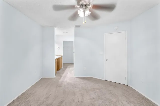a view of a hallway with a chandelier fan and windows