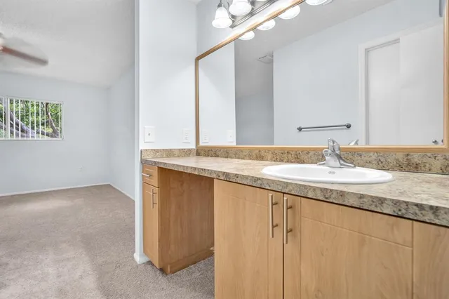 a bathroom with a granite countertop sink and a mirror