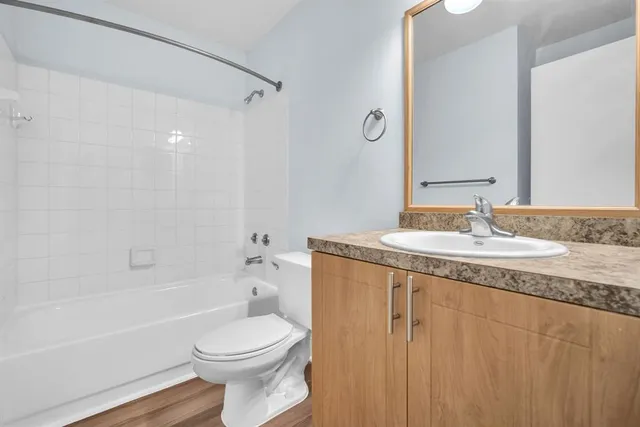 a bathroom with a granite countertop sink toilet and shower