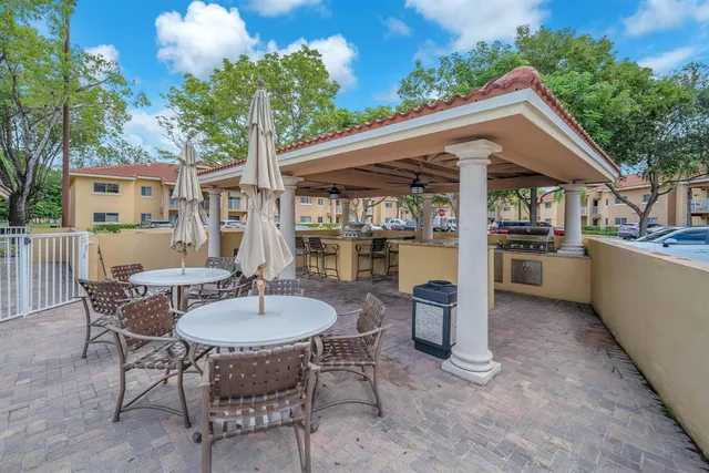 a patio with a table and chairs and a barbeque