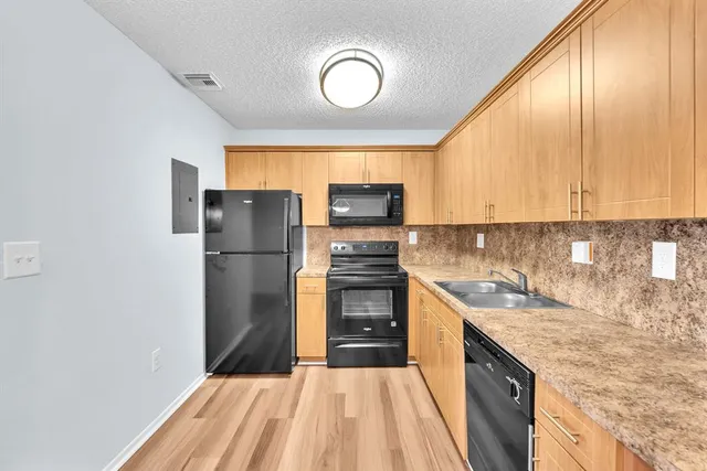 a kitchen with a sink a refrigerator and a stove