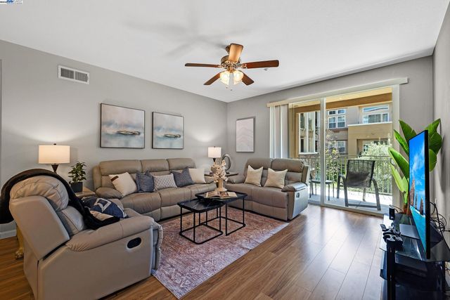 a living room with furniture a flat screen tv and a large window