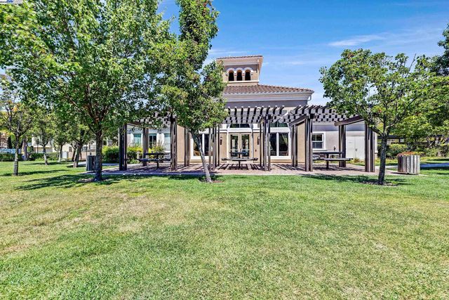 a view of a big house with a big yard and large trees