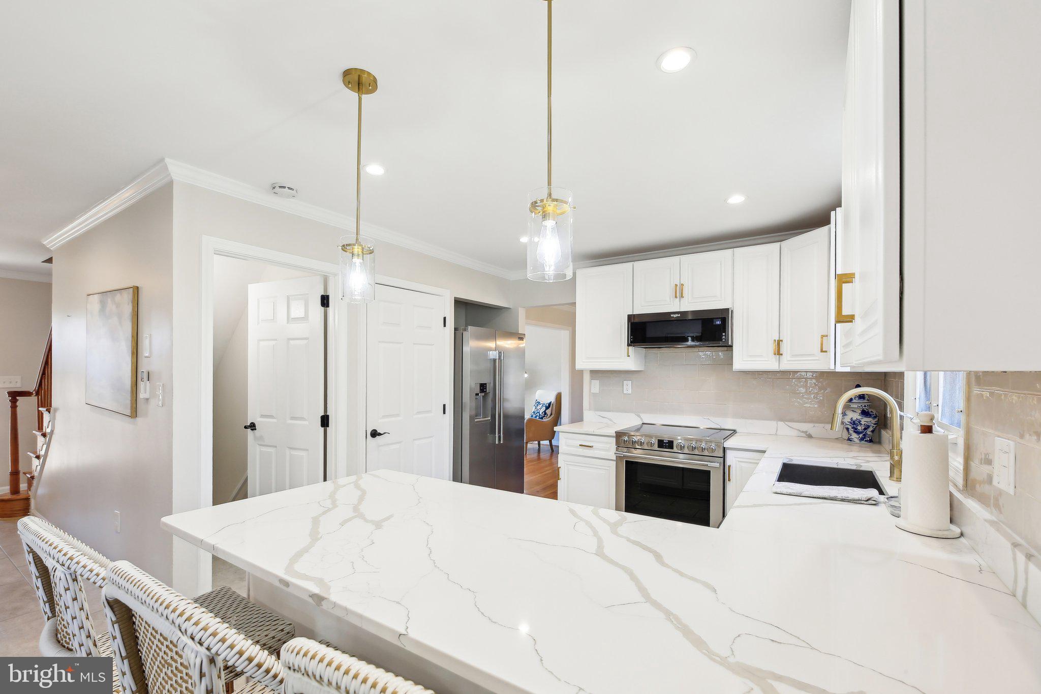 2139 Daisy Road Woodbine, MD 21797 - Photo 13 of 62 a kitchen with stainless steel appliances kitchen island granite countertop a refrigerator a sink a stove and white cabinets with wooden floor