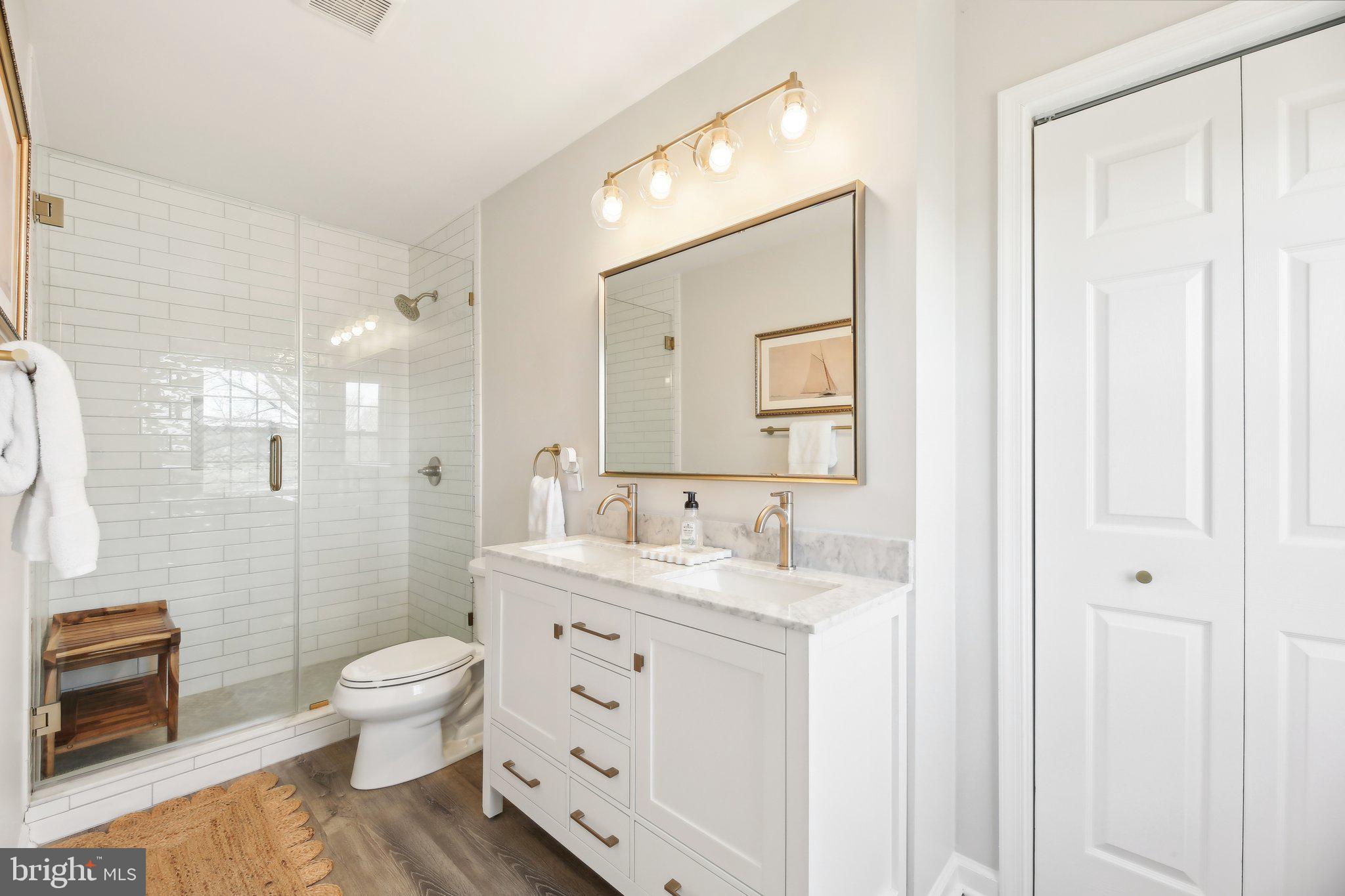 2139 Daisy Road Woodbine, MD 21797 - Photo 23 of 62 a bathroom with a double vanity sink toilet mirror and shower