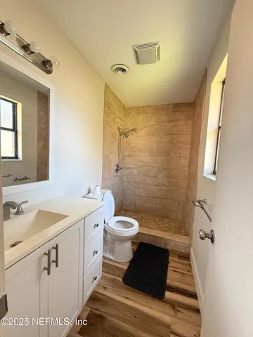 a bathroom with a sink a toilet a mirror and shower