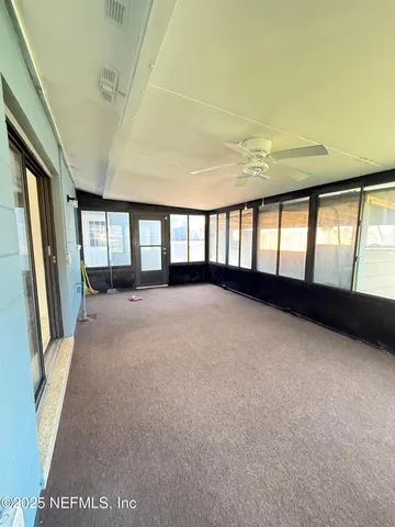 a view of an empty room with a fireplace and windows