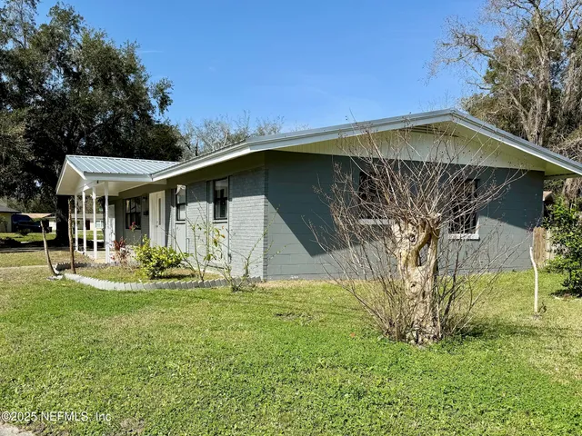 a view of a house with backyard and sitting area