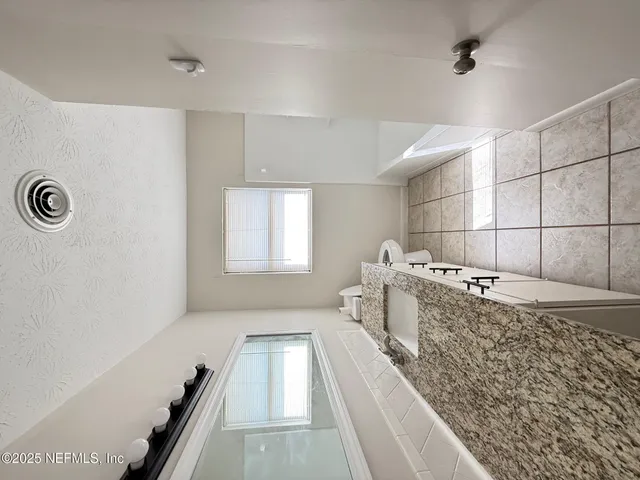 a large white room with a couch and a stove top oven