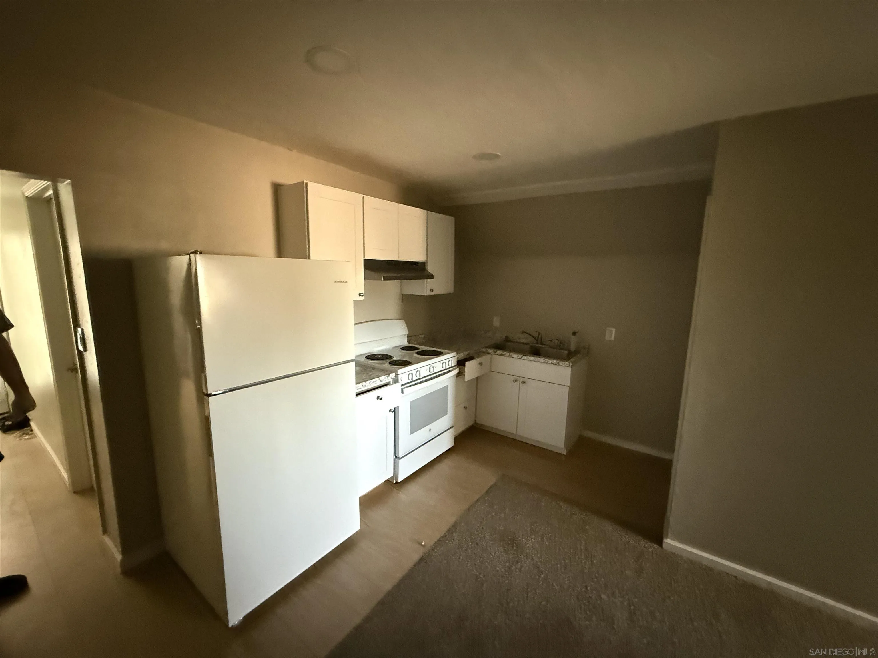 1431 Tierra Del Sol Road Boulevard, CA 91905 - Photo 6 of 9 a kitchen with a refrigerator a stove a sink and a more cabinets