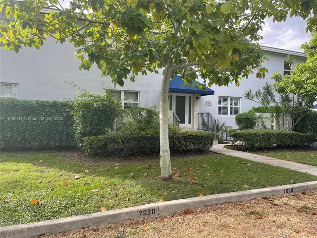 a view of a house with garden and a tree