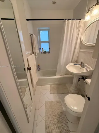 a white toilet sitting next to a bathroom sink and a shower