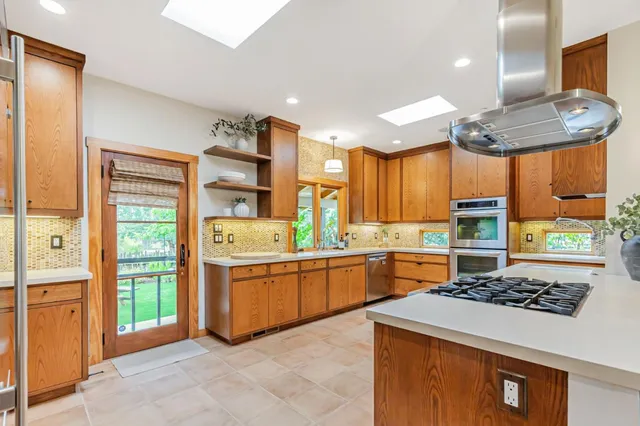 a view of a house with wooden fence next to a yard