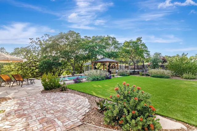 a view of a backyard with table and chairs under an umbrella