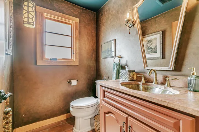 a view of a dining room with furniture a chandelier and large windows