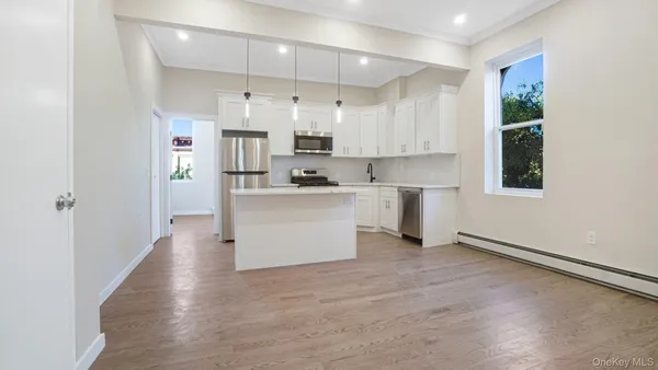 a kitchen with stainless steel appliances a sink a stove a refrigerator and white walls