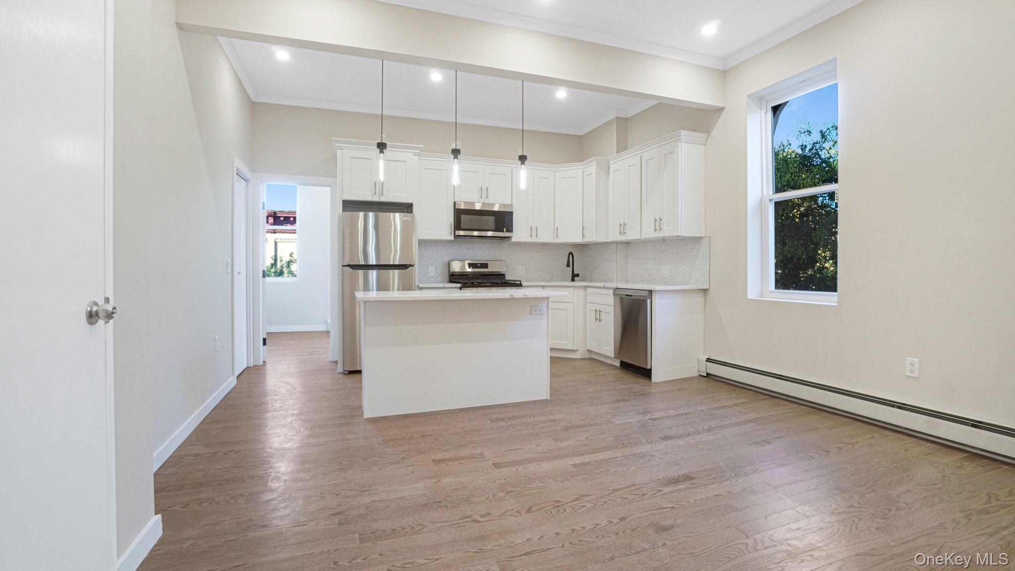 a kitchen with stainless steel appliances a sink a stove a refrigerator and white walls
