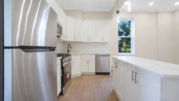 a kitchen with a white cabinets sink and stainless steel appliances