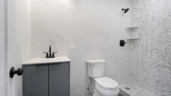 a white toilet sitting next to a shower
