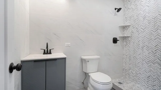 a white toilet sitting next to a shower