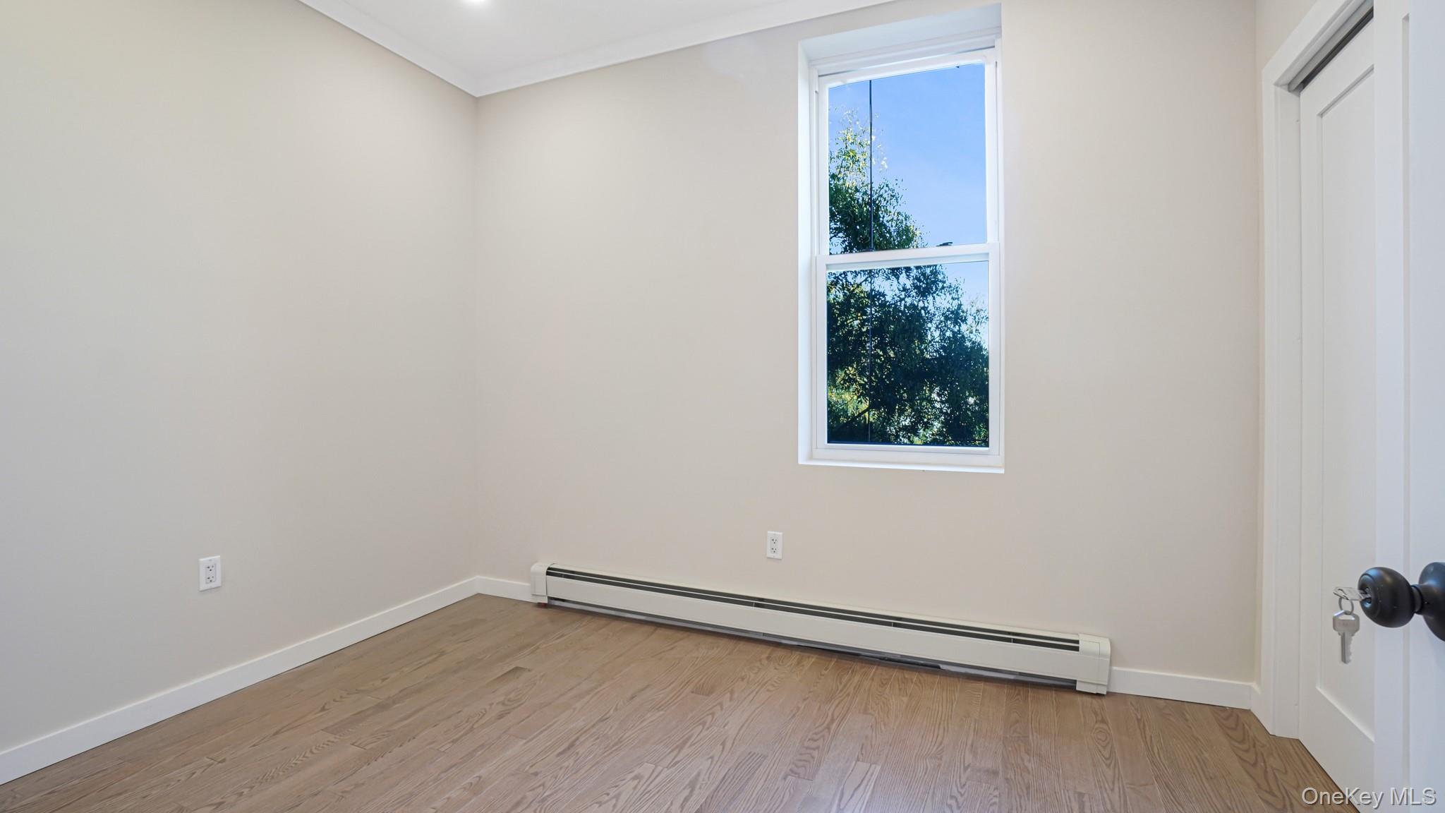 386 Chauncey Street, Unit 2 Brooklyn, NY 11233 - Photo 7 of 10 a view of an empty room with wooden floor and a window
