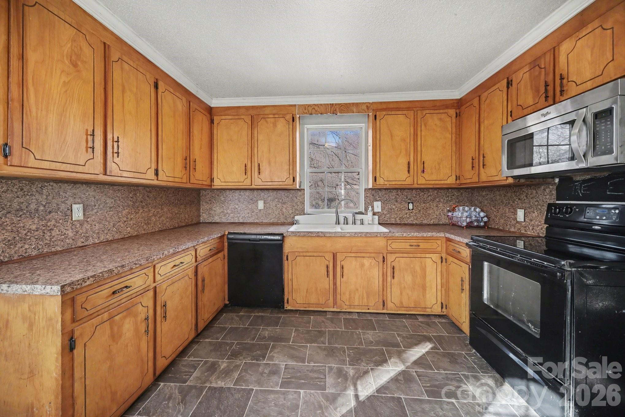 453 Robert Road Cherryville, NC 28021 - Photo 17 of 36 a kitchen with stainless steel appliances granite countertop a stove sink and cabinets