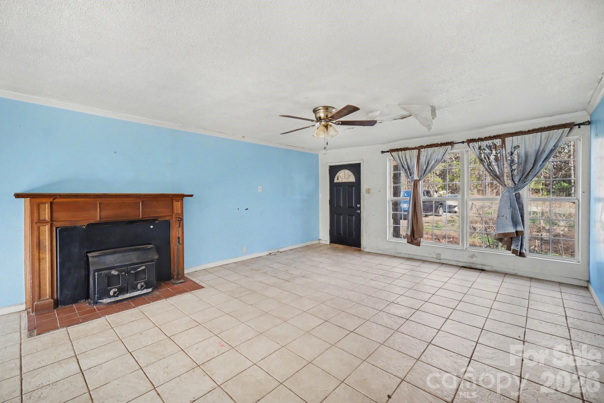 453 Robert Road Cherryville, NC 28021 - Photo 6 of 36 a view of an empty room with a fireplace and a window