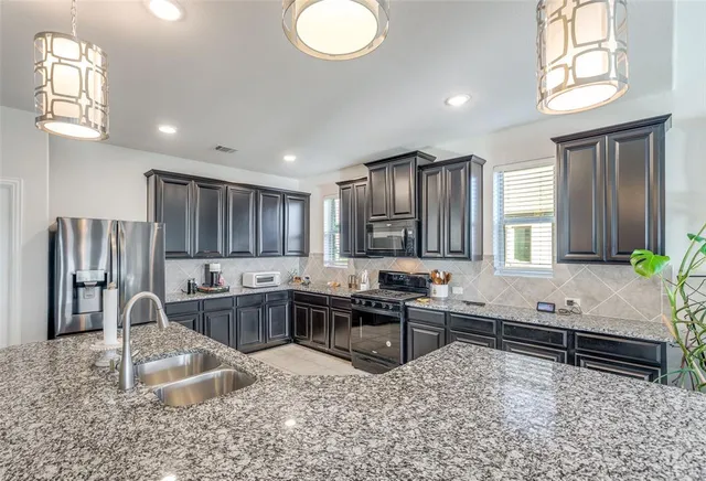 a kitchen with stainless steel appliances granite countertop lots of white cabinets a sink and dishwasher