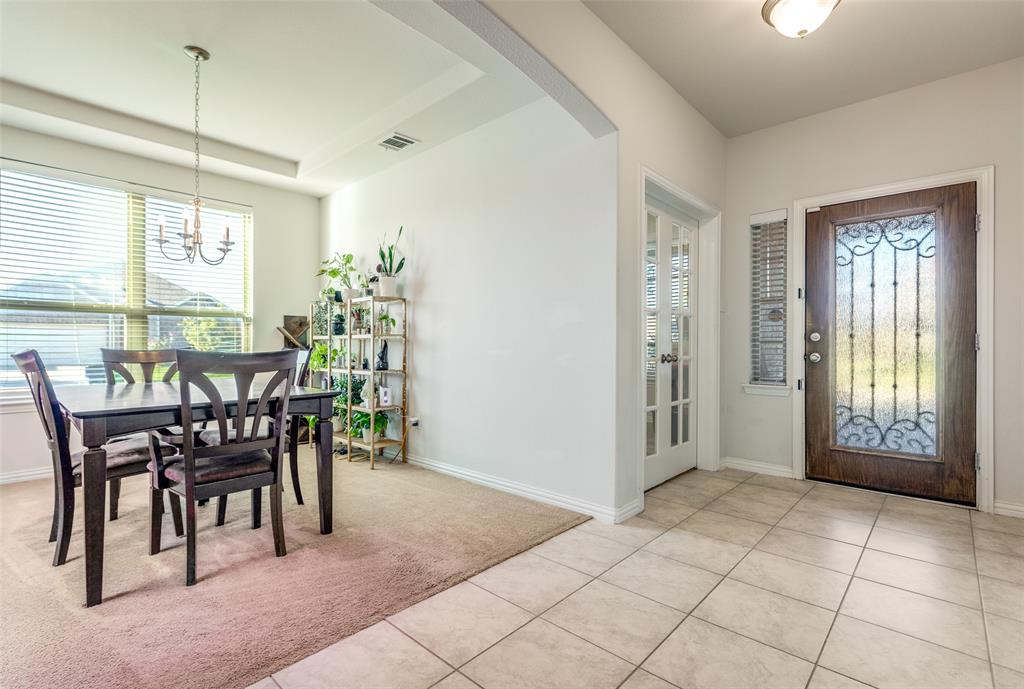 4542 Kipling Avenue Aubrey, TX 76227 - Photo 5 of 36 Entrance foyer featuring light tile patterned floors, arched walkways, a chandelier, light carpet, and a raised ceiling