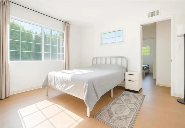 a bed sitting in a bedroom next to a window