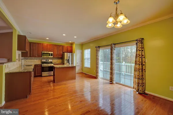a large kitchen with stainless steel appliances granite countertop a granite counter tops and a view of living room