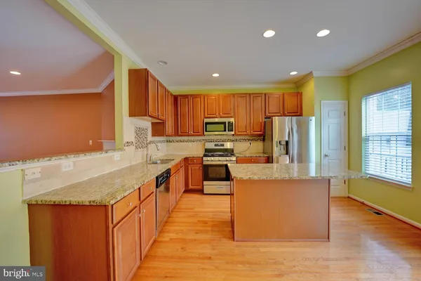 a kitchen with stainless steel appliances microwave stove refrigerator and wooden cabinets