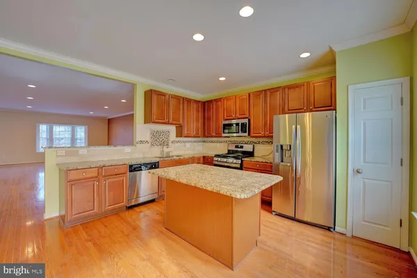 a large kitchen with stainless steel appliances granite countertop a stove top oven a sink and dishwasher