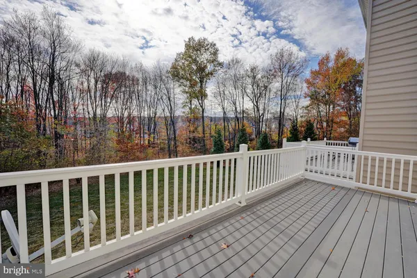 a view of a balcony with wooden floor and fence