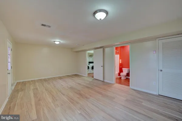 an empty room with wooden floor and closet