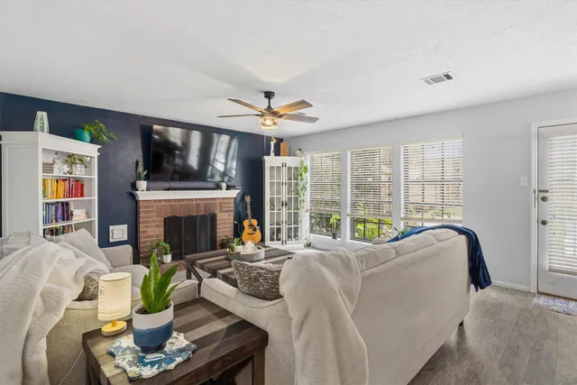 a living room with fireplace furniture and a floor to ceiling window