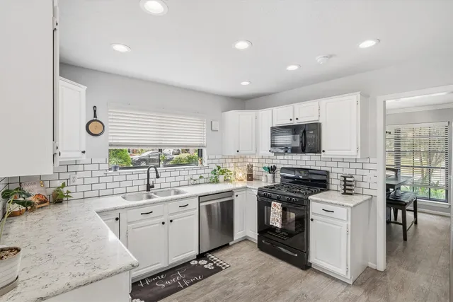 a kitchen with white cabinets stainless steel appliances and sink