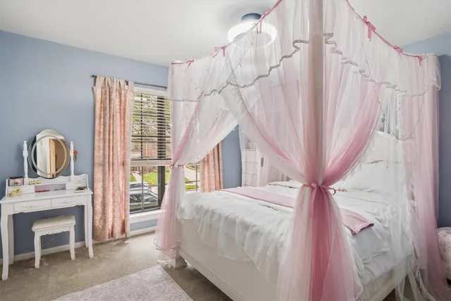 a bedroom with a bed chair and a window