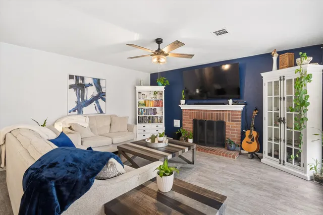 a living room with furniture a flat screen tv and a fireplace