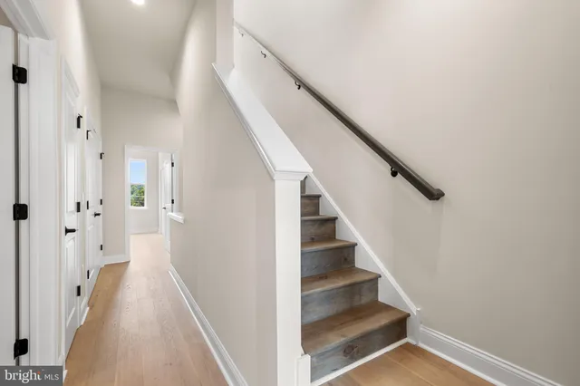 a view of a hallway with wooden floor and entryway