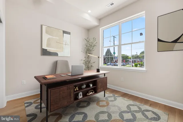 a view of a workspace with furniture and a window