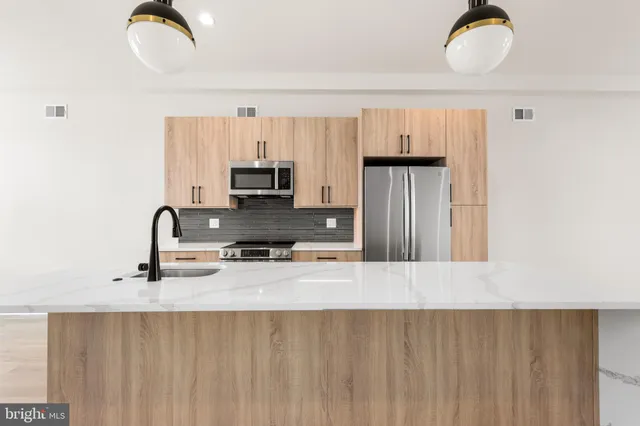 a kitchen with stainless steel appliances granite countertop a stove a sink dishwasher and a refrigerator