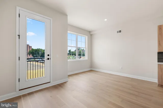 a view of an empty room with glass door and balcony