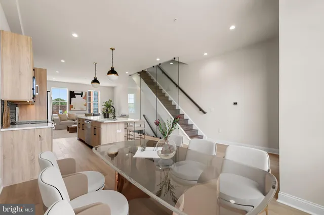 a living room with furniture kitchen view and a wooden floor