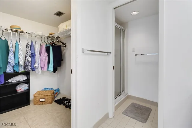 a view of walk in closet with clothes and shoes