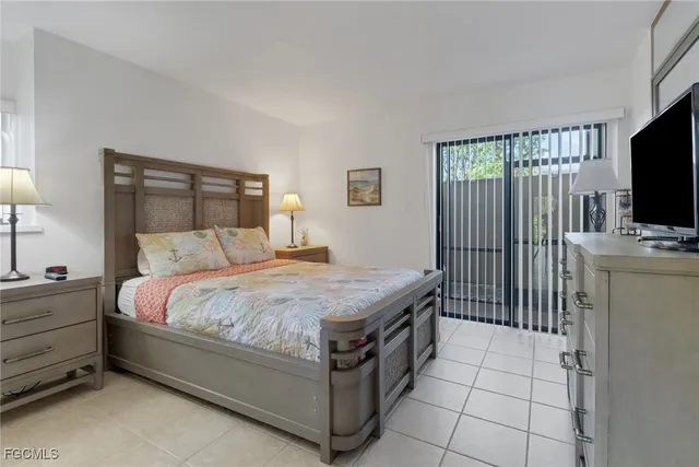 a bedroom with a bed and flat tv screen on the dresser